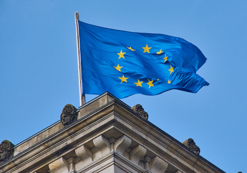 The EU flag waving atop a European building